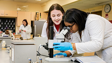 Two female students performing lab work