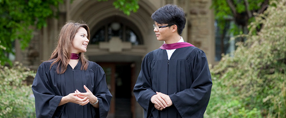 졸업 가운을 입고 야외에 서 있는 학생들